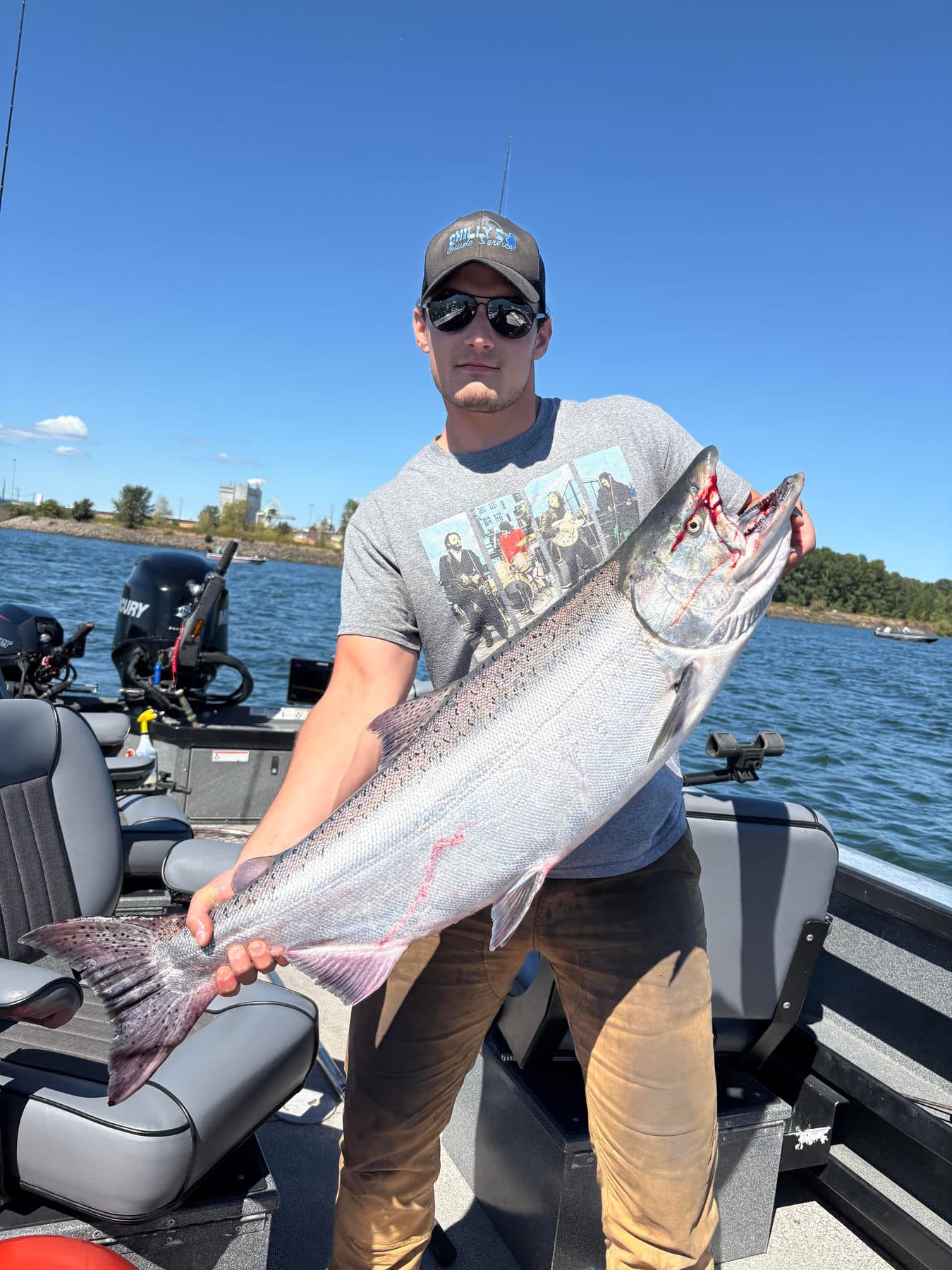 Angler in a Chilly's Guide Service hat holding a big Chinook
