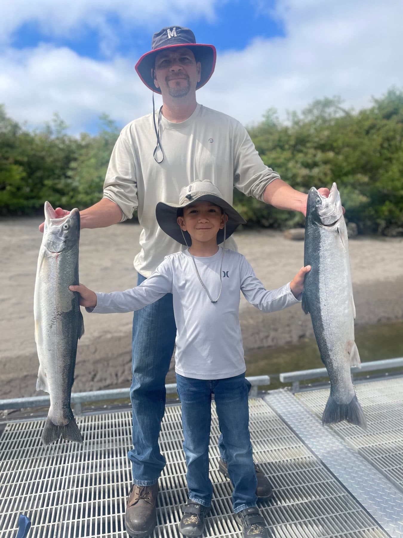 Father and young son each holding a salmon