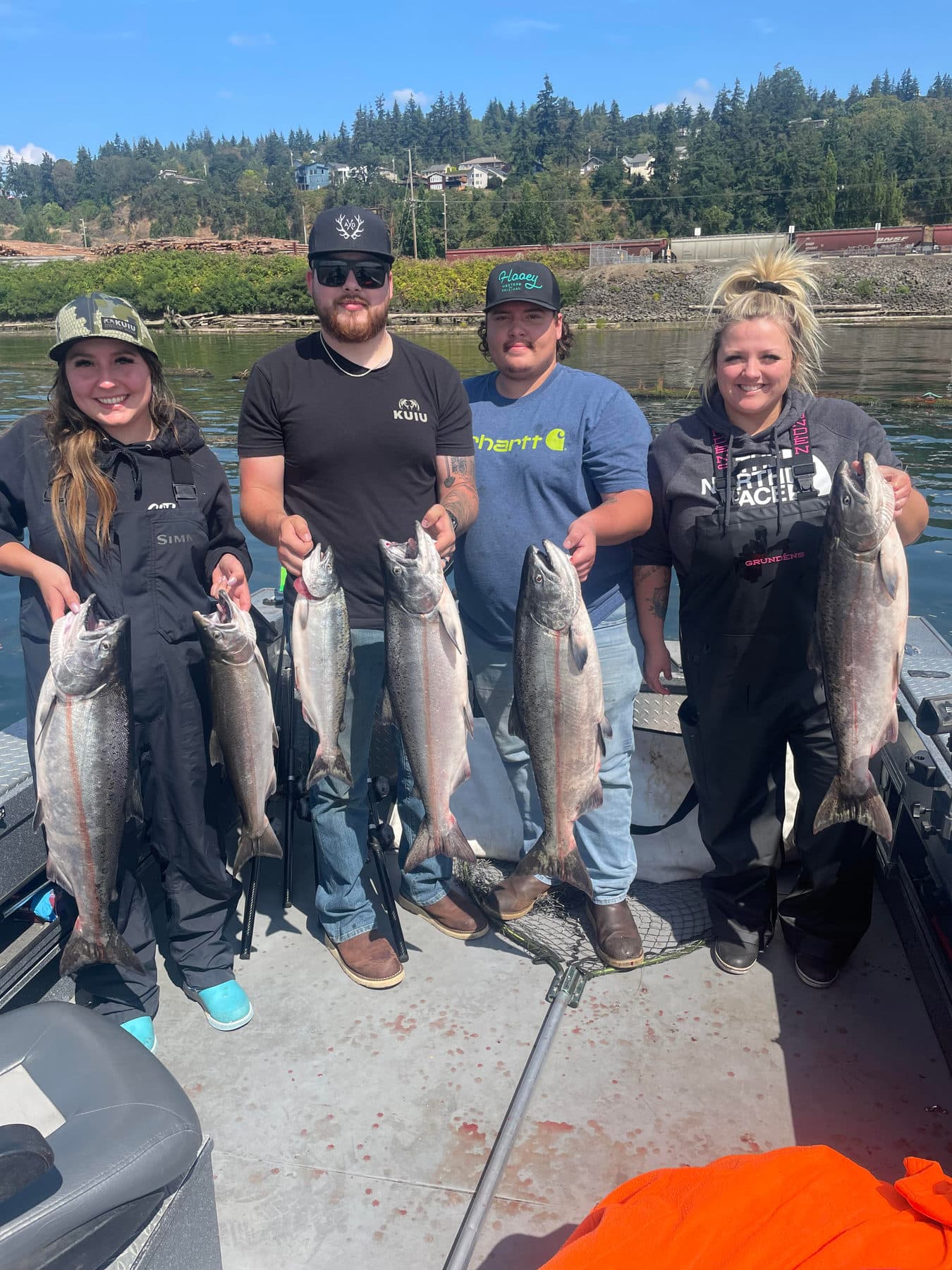 Group of friends holding salmon on a sunny day